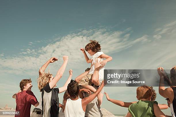boy being carried on shoulders - carrying on shoulders stock pictures, royalty-free photos & images