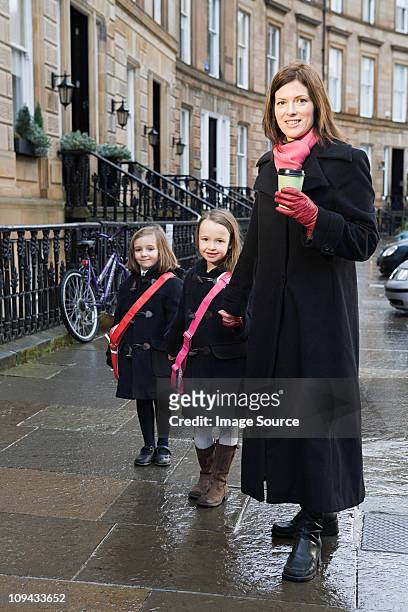 mother and two daughters standing on pavement - glasgow schotland stock pictures, royalty-free photos & images