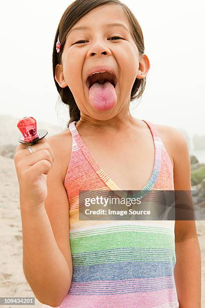 girl sticking out tongue, holding lollipop - candy on tongue stock pictures, royalty-free photos & images