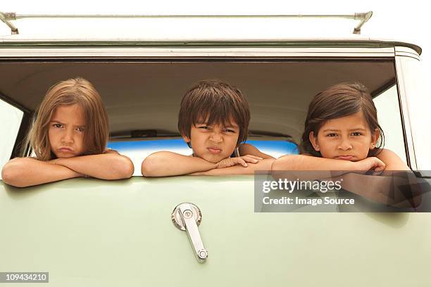 three sullen children in back of estate car - station wagon stock pictures, royalty-free photos & images