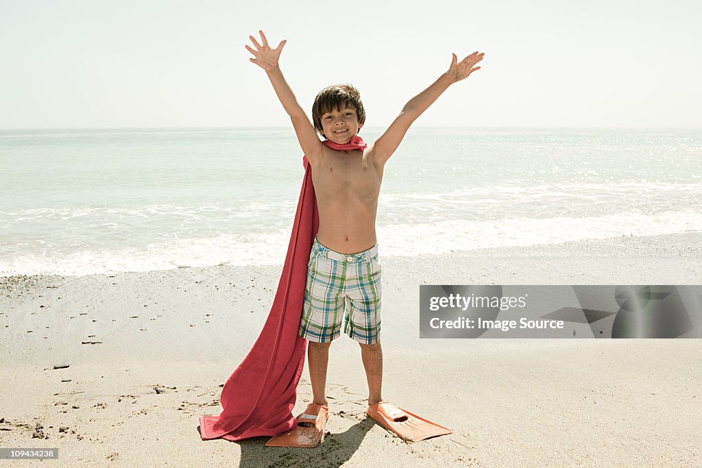 Menino usando flippers e vermelho na praia do Cabo