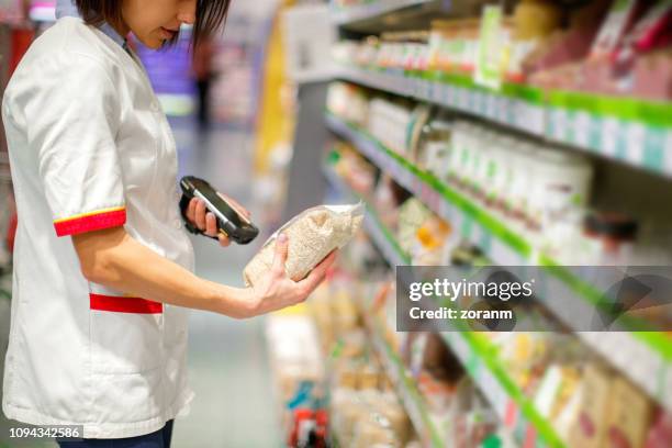 sales clerk checking bar code with portable reader - scan barcode stock pictures, royalty-free photos & images