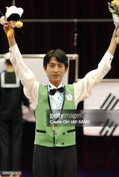 Taiwanese billiard player Yang Ching-Shun raises his arms on the winners's podium 05 October 2002 after winning the pool 9-ball singles final at the...
