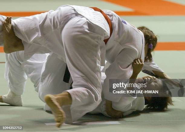 Taiwanese Liu Shu Yun in action with Uzbekistan's Lyudmila Kojemyakina during the Women's Judo under 70kg bronze match at the 14th Asian Games 2002,...