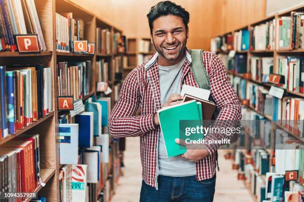 cheerful student with bunch of books - man holding book stock pictures, royalty-free photos & images