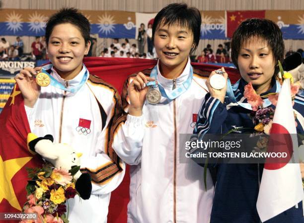 Chinese swimmer Xu Yanwei with gold, teammate Yang Yu with silver and Japan's Tomoko Nagai display their medal on the winner's podium 02 October 2002...