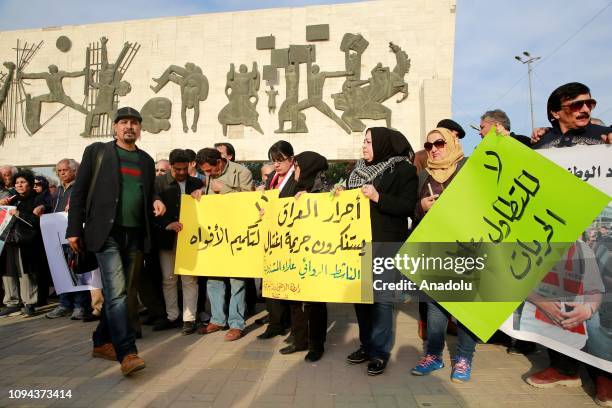 People hold placards as they stage a protest for the killing of Iraqi novelist Alaa Mashzoub at Tahrir Square in Baghdad, Iraq on February 06, 2019.