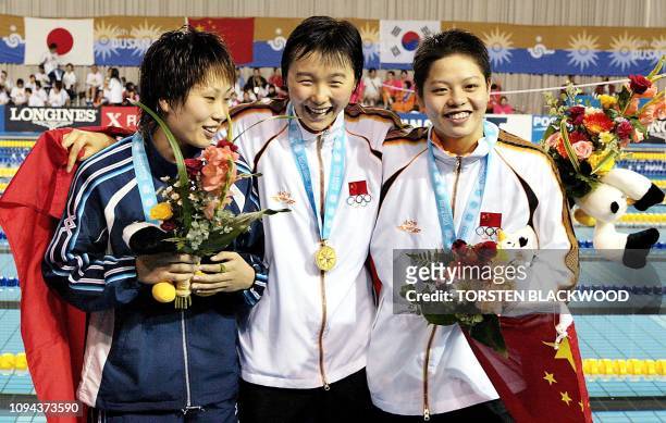 Winners of the women's 200m freestyle event China's Yang Yu , compatriot Xu Yanwei and Tomoko Nagai of Japan share a light moment after receiving...