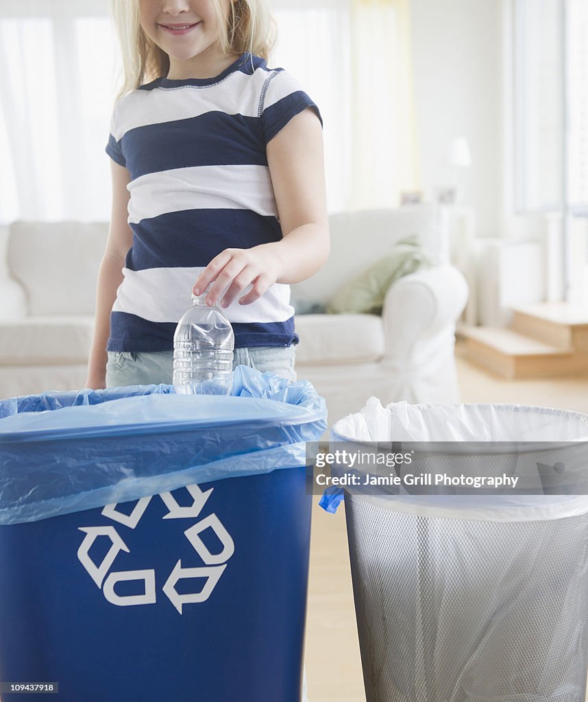 USA, New Jersey, Jersey City, Girl (8-9) putting plastic bottle into recycling bin