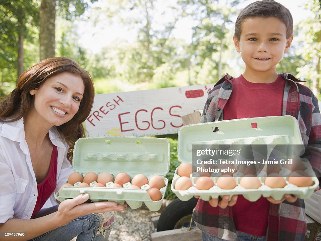 USA, New York, Flanders, Mother and son (8-9) selling fresh eggs