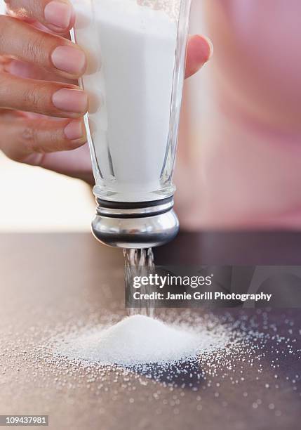 usa, new jersey, jersey city, woman hand holding salt shaker upside down - salt shaker imagens e fotografias de stock