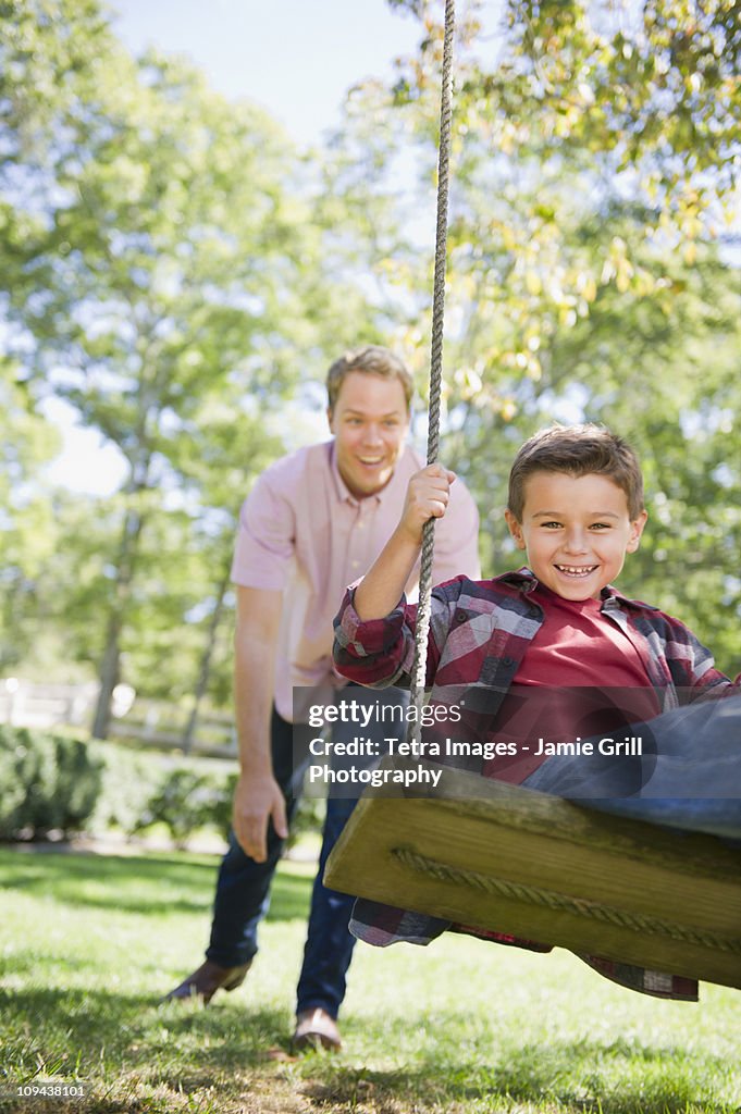 USA, New York, Flanders, Father and son (8-9) playing in garden