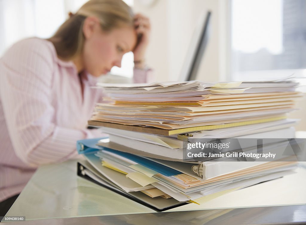 USA, New Jersey, Jersey City, Stressed young businesswoman doing paperwork