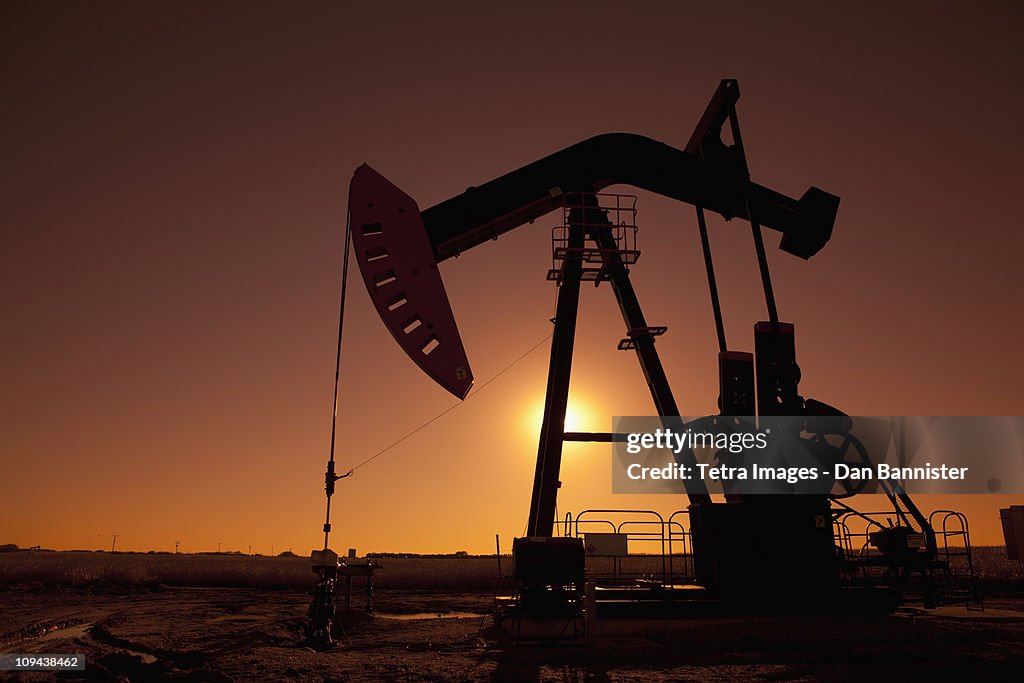 Silhouette of oil pump jack on rig