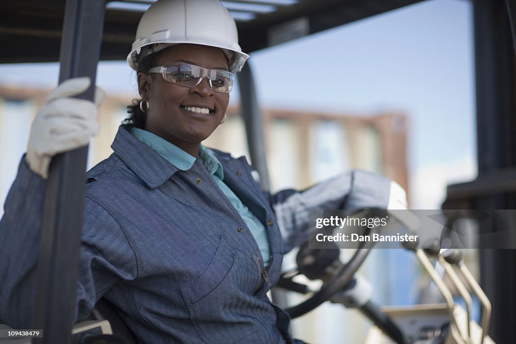 Portrait of female construction worker driving mechanical digger