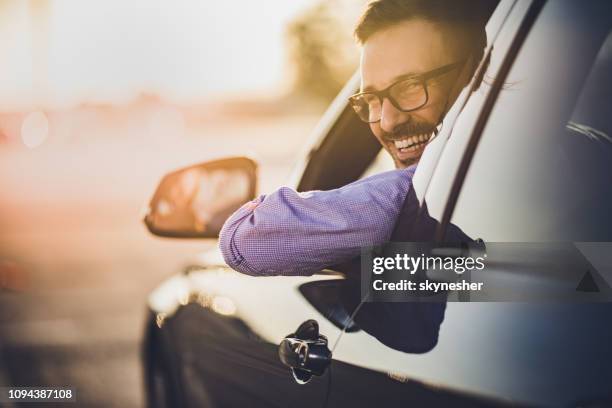 gelukkig jongeman besturen van een auto bij zonsondergang. - driving a car stockfoto's en -beelden