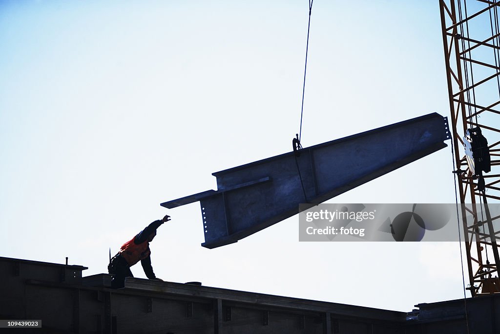 USA, New York City, girder being lifted at construction site