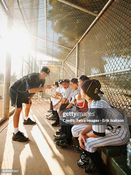 usa, california, ladera ranch, boys (10-11) from little league sitting on dugout while coach talking - banco dos jogadores imagens e fotografias de stock