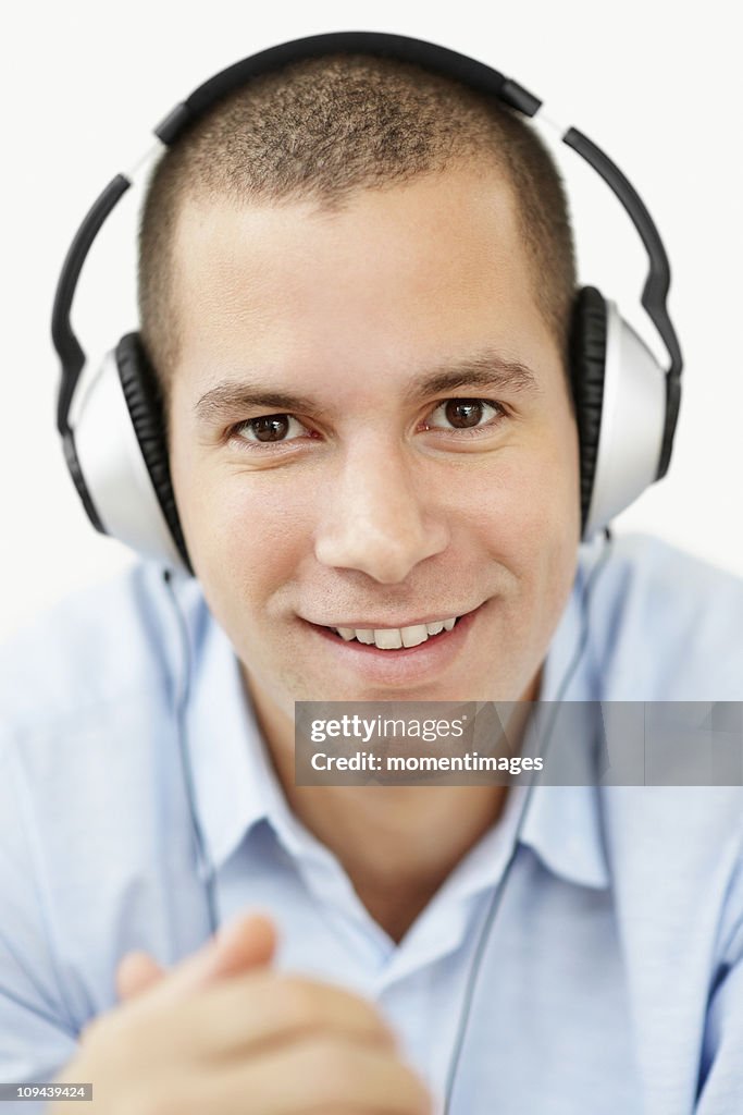 South Africa, Young man wearing earphones and looking at camera, studio shot