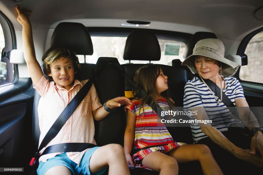 Grandmother with grandchildren traveling in taxi
