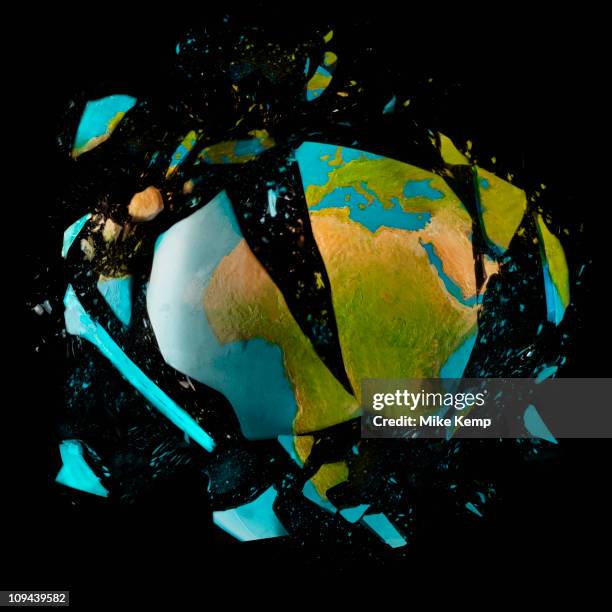 exploding globe on black background - world destruction stock pictures, royalty-free photos & images