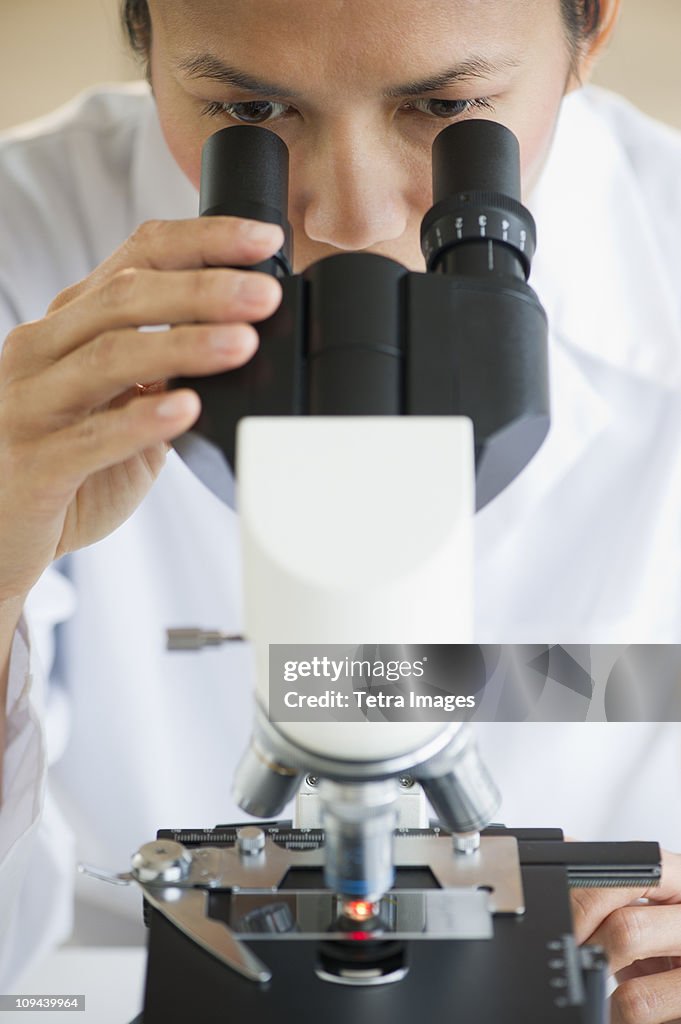 USA, New Jersey, Jersey City, Female scientist using microscope