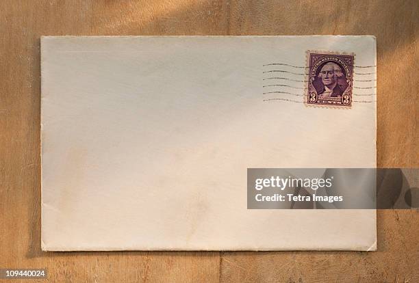 blank envelope on wooden table - message ストックフォトと画像