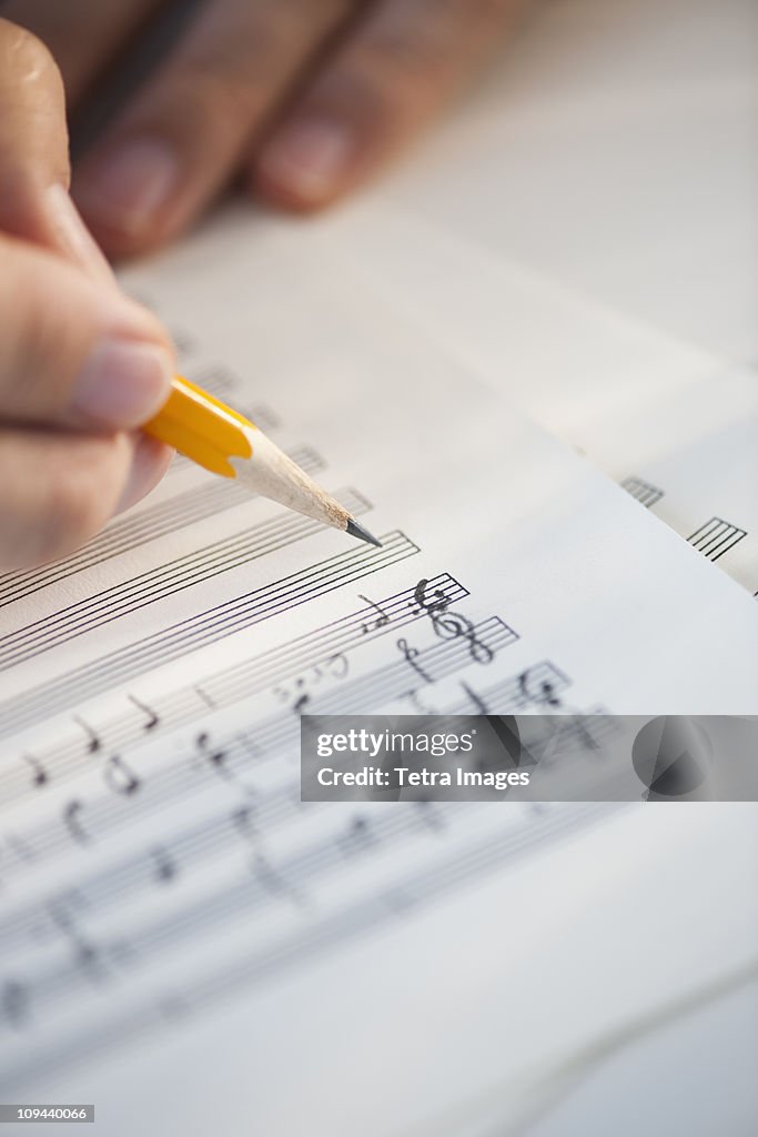 Man writing notes on sheet music