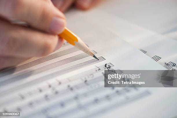 man writing notes on sheet music - writing music stock pictures, royalty-free photos & images