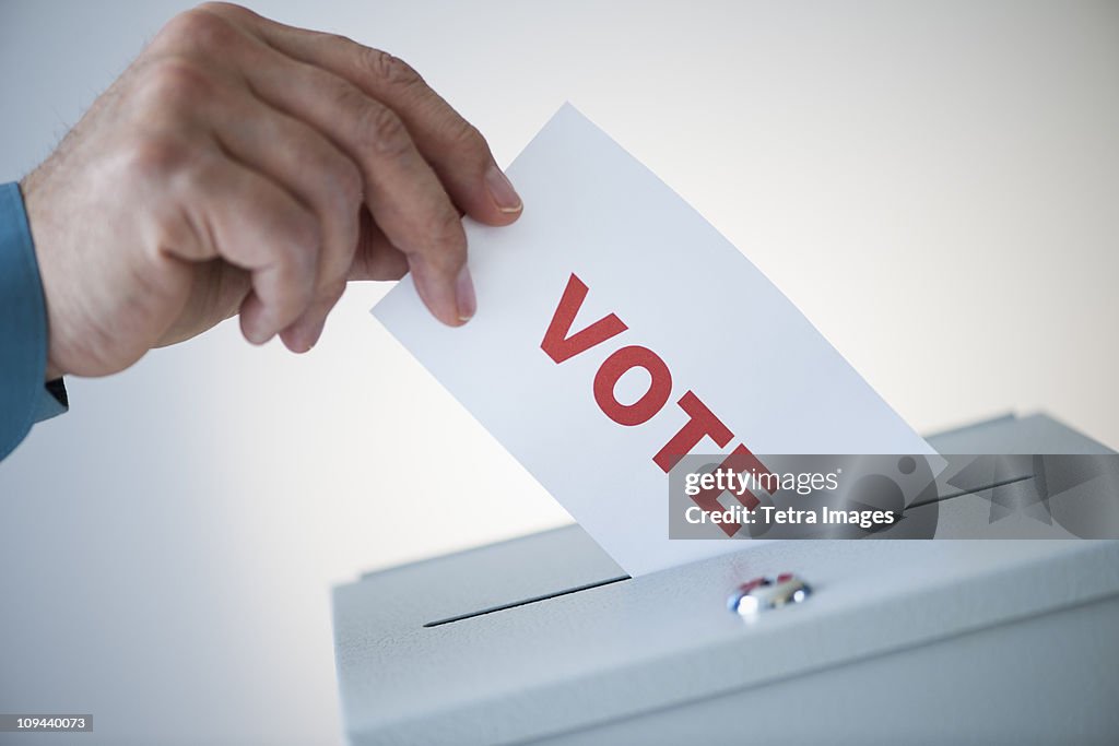 Man putting vote card into box
