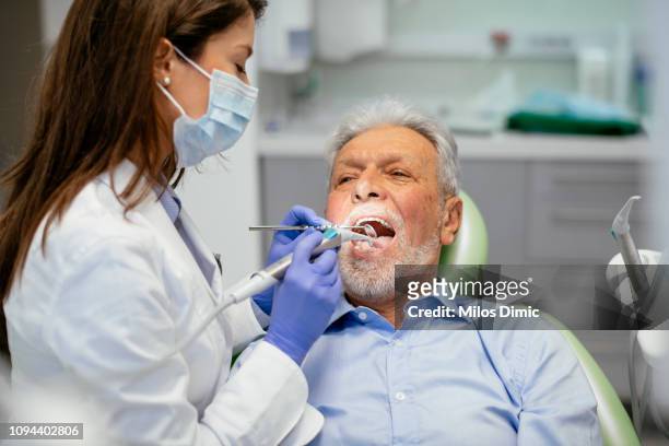 ältere menschen beim zahnarzt - zahnarztstuhl stock-fotos und bilder