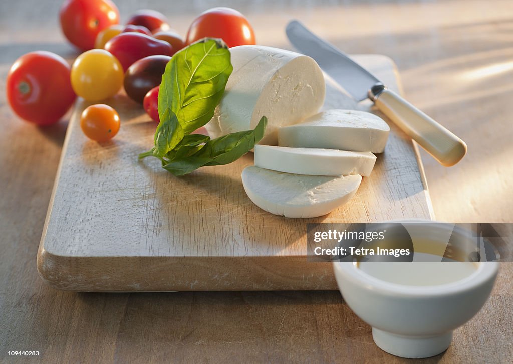 Mozarella and tomatoes on chopping board