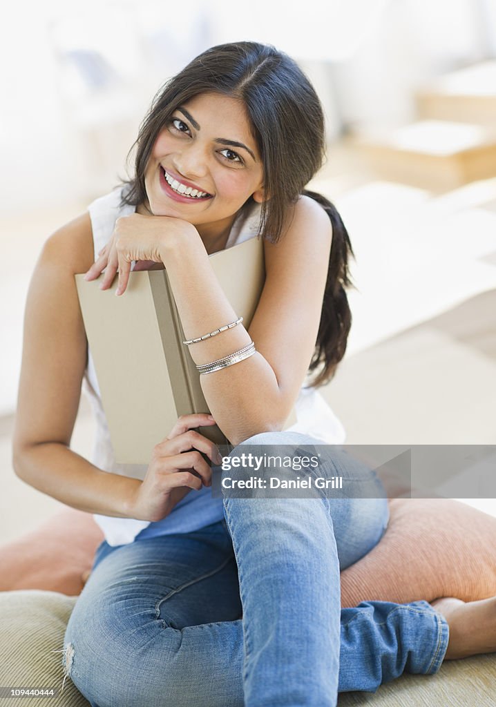 USA, New Jersey, Jersey City, Young attractive woman portrait, posing with book