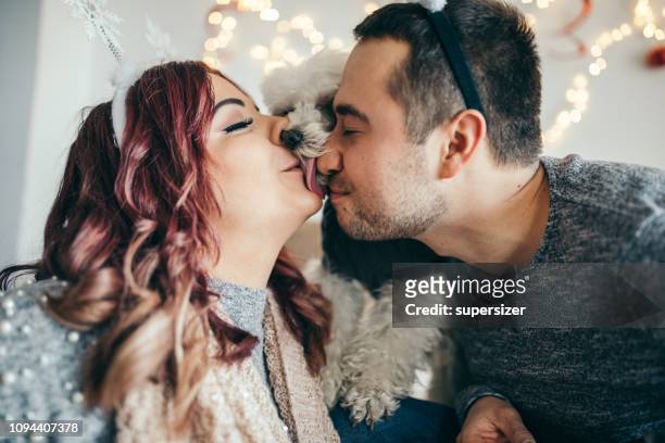 tausendjährige paar spiel mit niedlichen hund - couple tongue kissing stock-fotos und bilder