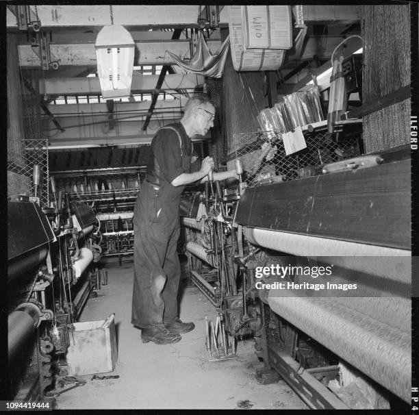 Weaver operating a Jacquard power loom, 1966-1974. A weaver operating a Jacquard power loom. The location of this site is unidentified, but it is...