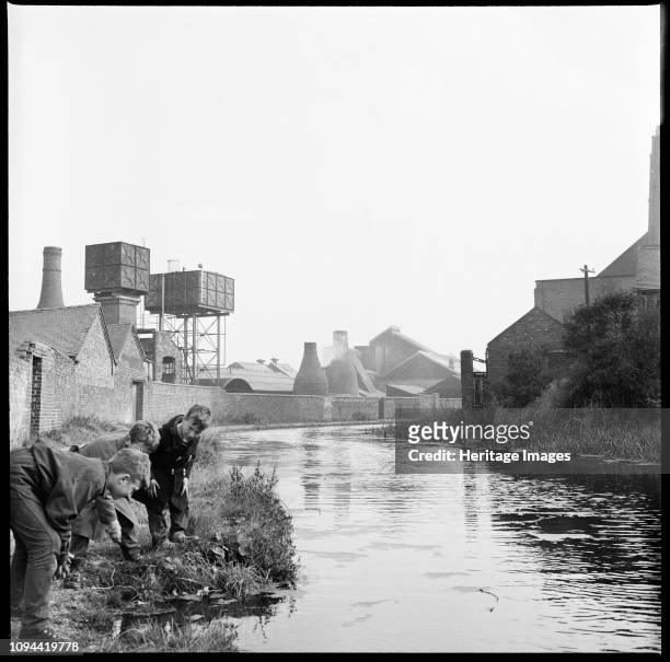 Caldon Canal, Joiner's Square, Hanley, Stoke-on-Trent, Staffordshire, 1965-1968. Three boys scrutinizing the waters of the Caldon Canal from a point...