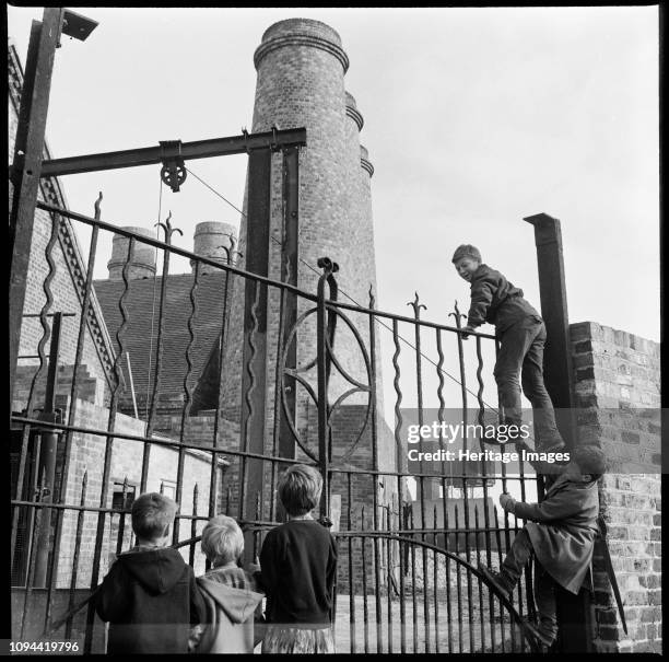 Westwood Mills, Lichfield Street, Hanley, Stoke-on-Trent, Staffordshire, 1965-1968. A group of children climbing the wrought iron gates at the canal...