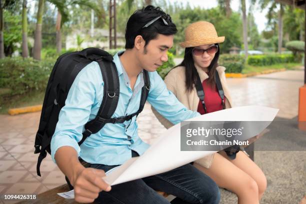 travel and transportation concept, multi ethnic travellers are looking at the map at the train station - passenger train stockfoto's en -beelden