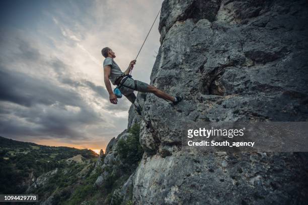 Disability man climbing high on rock mountain