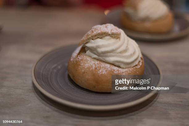 semla (plural semlor) are cream buns, with almond paste, traditionally eaten on, or before, shrove tuesday in sweden / scandinavia. also known as fastlagsbulle, laskiaispulla, vastlakukkel, fastelavnsbolle - pancake day - fotografias e filmes do acervo
