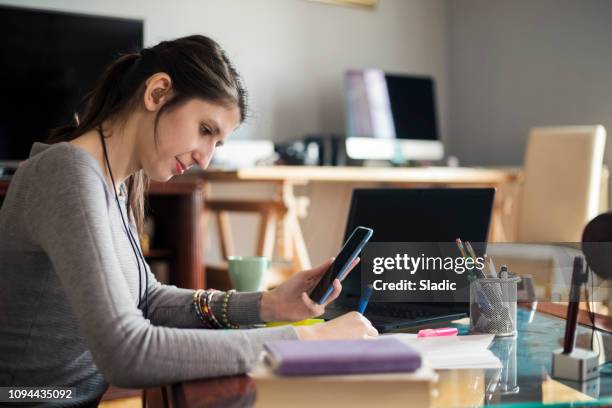 young woman designer working at home - hearing loss at work stock pictures, royalty-free photos & images
