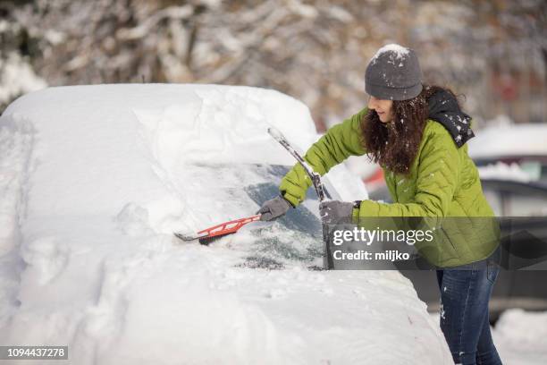 femme, nettoyage de sa voiture de la neige - frost stock photos et images de collection