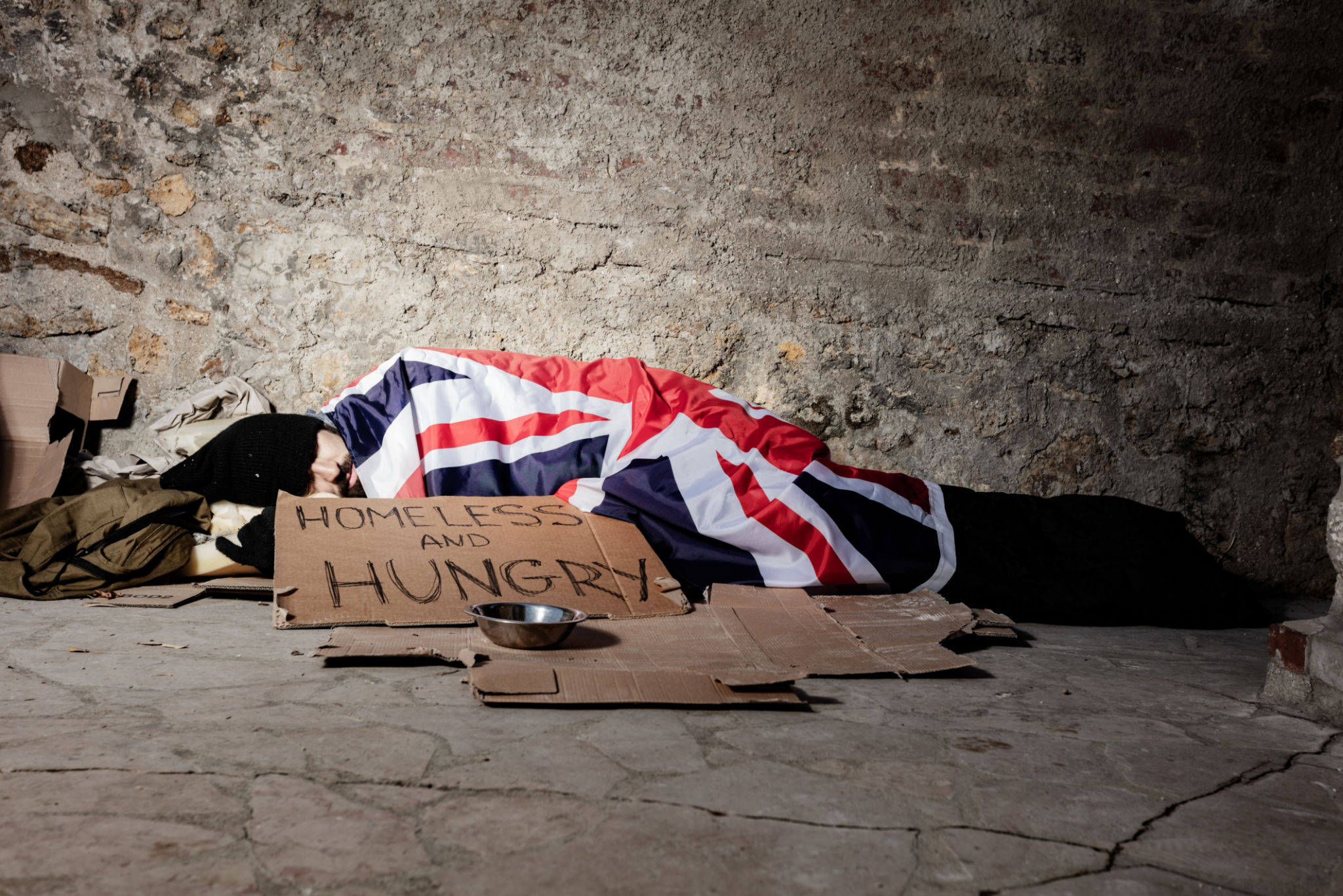 Man sleeping on street under Great Britain flag Man sleeping on street under Great Britain flag