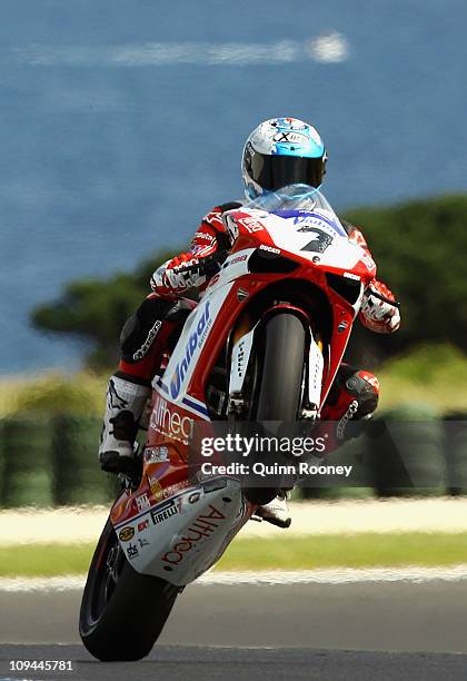 Carlos Checa of Spain lifts the front wheel after taking pole on the Althea Racing Ducati during qualifying for round one of the Superbike World...