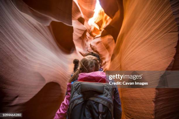 rear view of father carrying daughter while walking amidst rock formations at page - grand canyon national park stockfoto's en -beelden