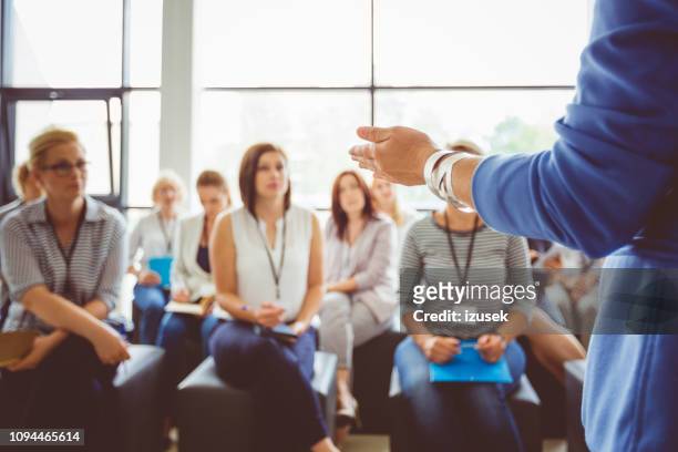 speaker addressing group of females - person in education stock pictures, royalty-free photos & images
