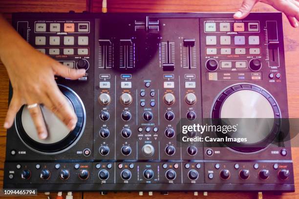 cropped hands of female dj mixing sound on table in recording studio - dj table stock pictures, royalty-free photos & images