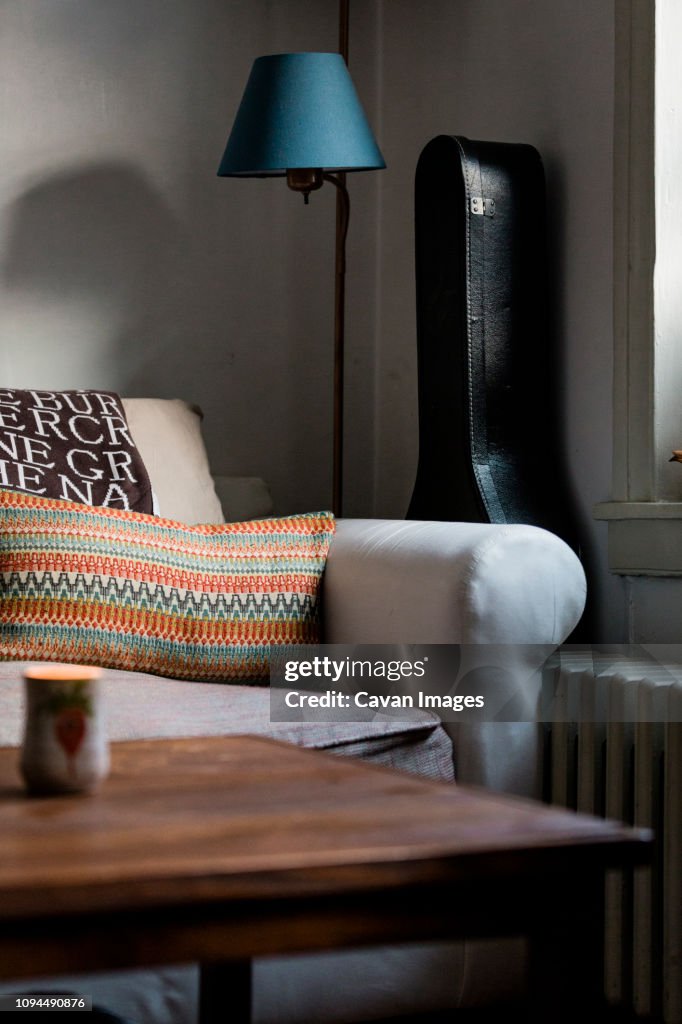 Furniture with guitar case in living room at home