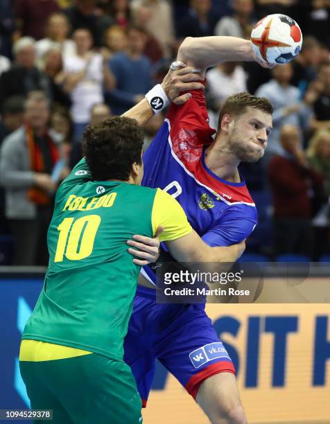 Dmitrii Zhitnikov of Russia is challenged by Jose Toledo of Brazil during the 26th IHF Men's World Championship group A match between Russia and...
