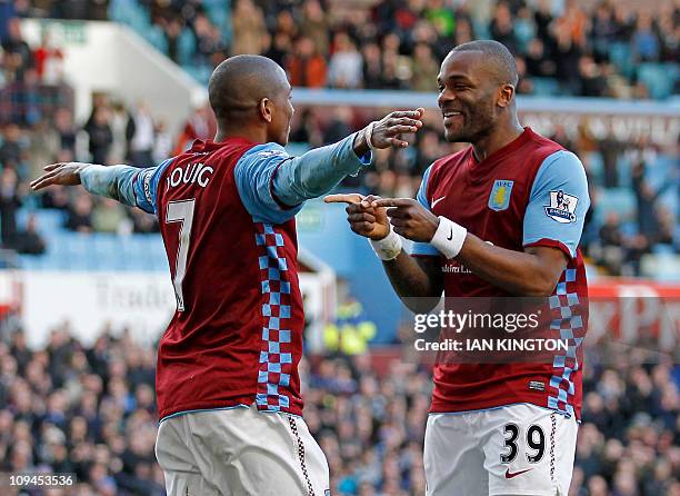 Aston Villa's English midfielder Ashley Young celebrates scoring the opening goal with English striker Darren Bent during the English Premier League...